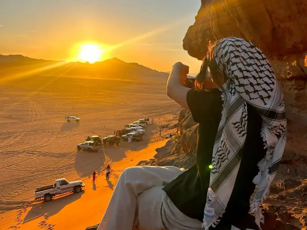 Tourists enjoying a Bedouin-style sunset view over the Wadi Rum desert